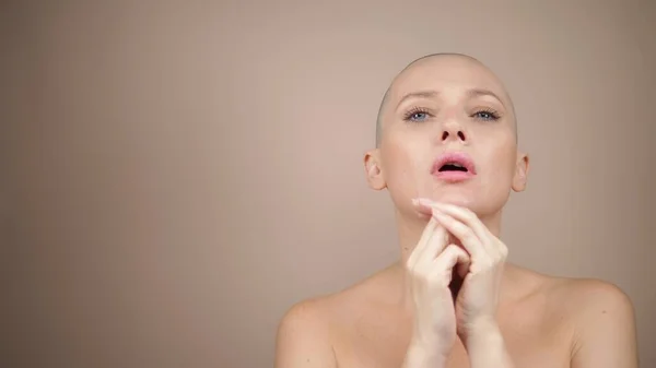 Bald woman folding her hands in prayer. beige background — Stock Photo, Image