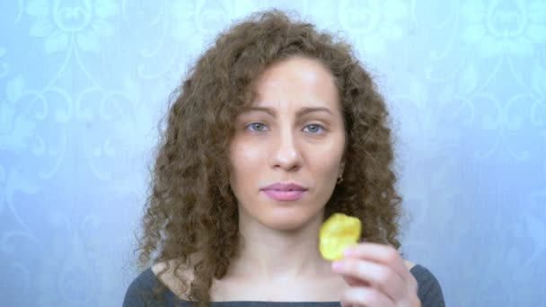 Piękna kręcone dziewczyna z przyjemnością je chipsy ziemniaczane. portret — Wideo stockowe