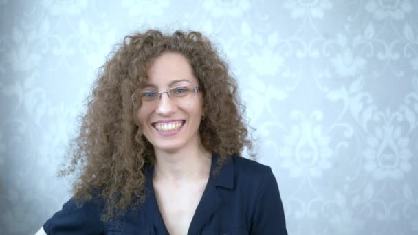 Porträt. Schöne lächelnde Frau mit Brille und lockigem Haar — Stockvideo