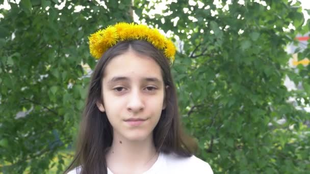 Gadis berambut cokelat dengan rambut panjang dengan karangan bunga dandelion di kepalanya. potret — Stok Video