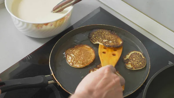 Close up, someone is cooking pancakes in a pan on a touch stove — Stock Photo, Image