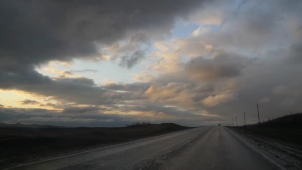 Leere Autobahn in einem Feld. der Horizont und donnernde Wolken — Stockvideo