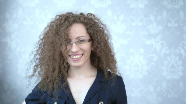 Портрет. Красивая улыбающаяся женщина в очках с вьющимися волосами — стоковое фото