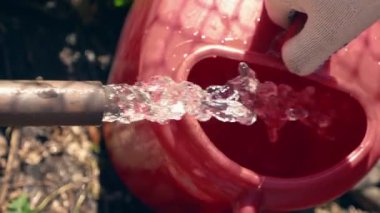 Bahçe bakımı kavramı. Yakın plan. Musluk suyu bir su bidonuna akar.