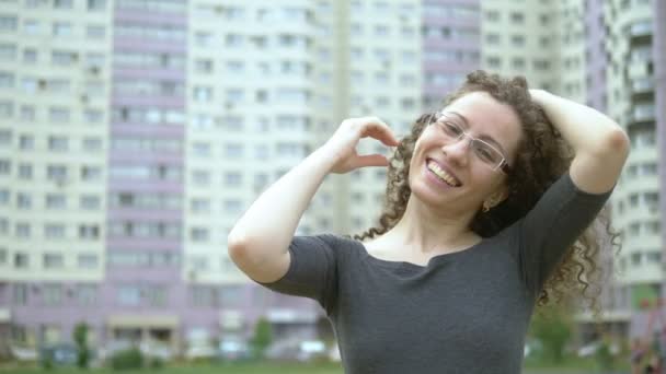 巻き毛の女性は街の通りに立って髪に触れ — ストック動画