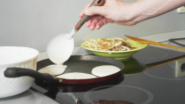 Yaklaş, birisi tencerede krep pişiriyor.