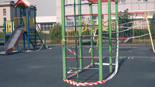 Empty playground during the coronavirus pandemic. warning tapes on the rides — Stock Photo, Image