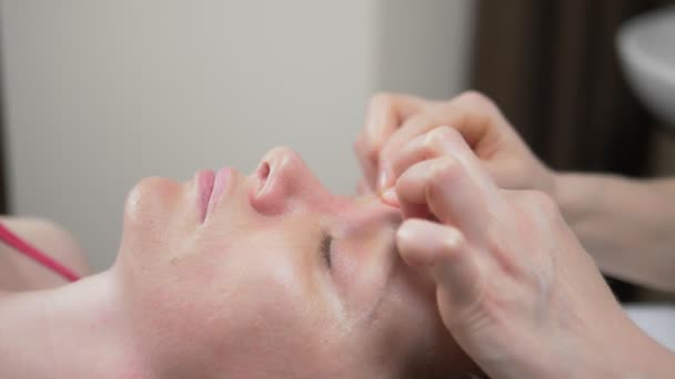 Masér dává ženě anti-aging masáž obličeje v lázních. detailní — Stock video