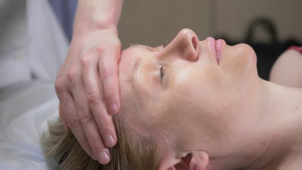 Masażystka masuje kobiecie twarz w spa. zbliżenie — Wideo stockowe