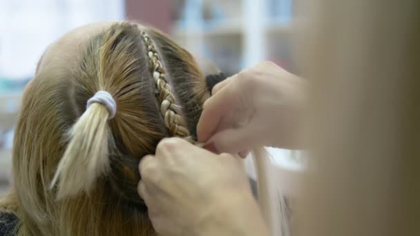 Närbild. frisör gör afro flätor till en blond flicka — Stockvideo