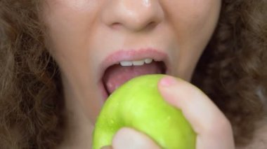 Dudaklar kapansın. Güzel bir kadın sulu yeşil bir elmayı ısırır.