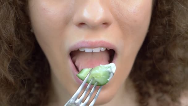 Labios de primer plano. mujer comiendo un pepino con salsa de un tenedor . — Vídeo de stock