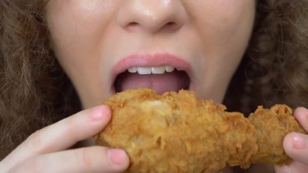 Gros plan des lèvres. belle femme mange aile de poulet frit. restauration rapide — Video