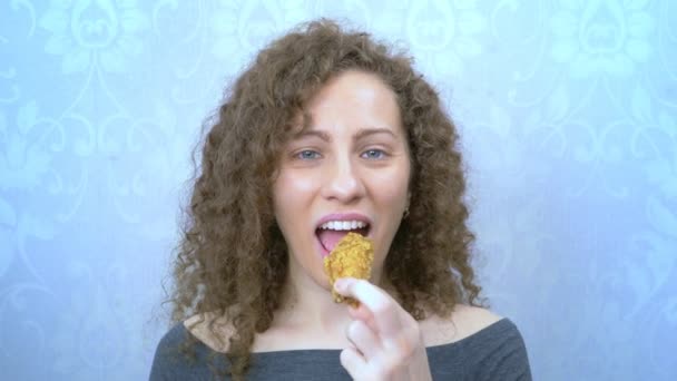 Porträt. schöne Frau, die einen gebratenen Hühnerflügel isst. Fast Food — Stockvideo
