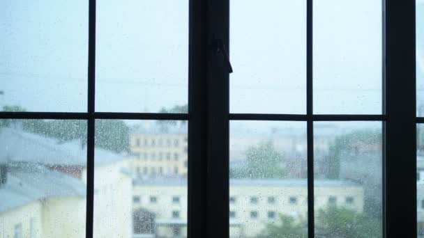 Regndroppar på glasfönster med utsikt över staden. suddighet, kopiera utrymme — Stockvideo