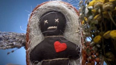 Süper yakın çekim. Bir voodoo bebeğinin detayları ve sepetteki kurutulmuş bitkiler.