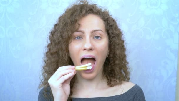 Mooie vrouw met krullend haar eet frietjes. close-up — Stockvideo