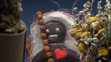 Süper yakın çekim. Bir voodoo bebeğinin detayları ve sepetteki kurutulmuş bitkiler.