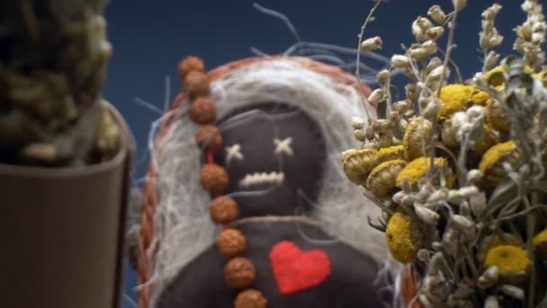 Súper cerca. detalles de una muñeca vudú y racimos de hierbas secas en una cesta — Vídeo de stock