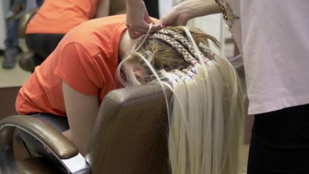 Fechar. cabeleireiro fazendo afro tranças para uma menina loira — Vídeo de Stock