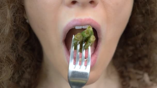 Primer plano de los labios. mujer feliz comiendo frijoles con un tenedor — Vídeo de stock