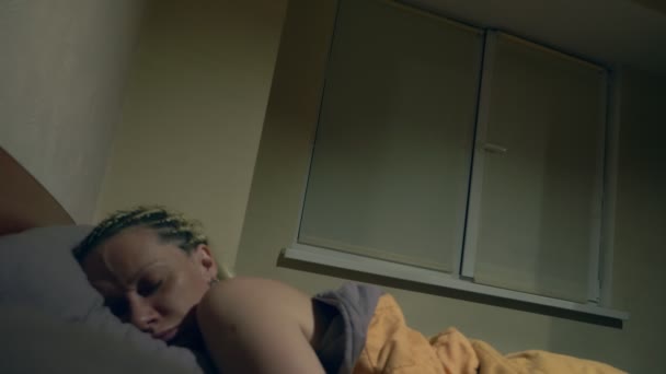 Η γυναίκα κοιμάται στο κρεβάτι το βράδυ. το παράθυρο ανοίγει ξαφνικά — Αρχείο Βίντεο