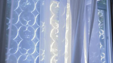 İşlenmiş demir ızgaralarla şeffaf pencere rüzgarla hafifçe hareket ediyor.