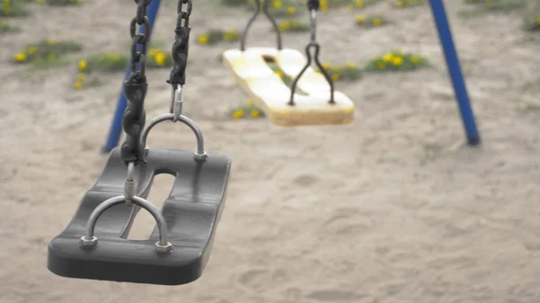 Empty swinging swing in the playground. closeup. copy space — Stock Photo, Image