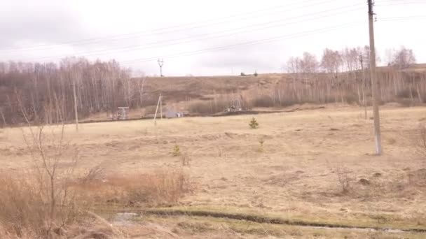 Líneas eléctricas en el campo a lo largo de la carretera. vista desde la ventana de un coche en movimiento — Vídeo de stock