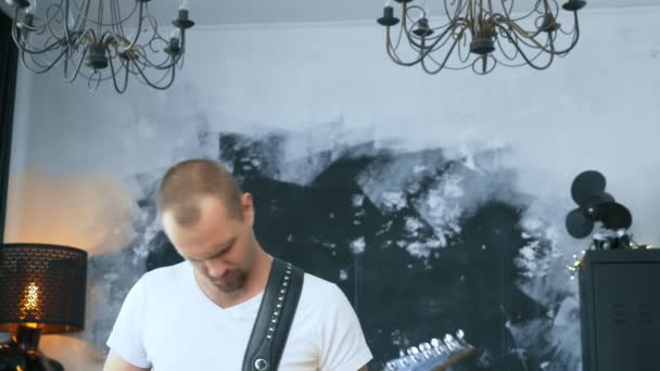 Przystojny mężczyzna rock muzyk gra a elektryczne gitara w stylizowane studio — Wideo stockowe