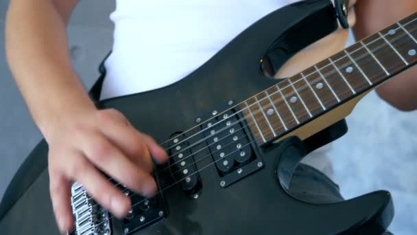 De cerca. manos de un músico masculino tocando una guitarra eléctrica con un pico — Vídeos de Stock