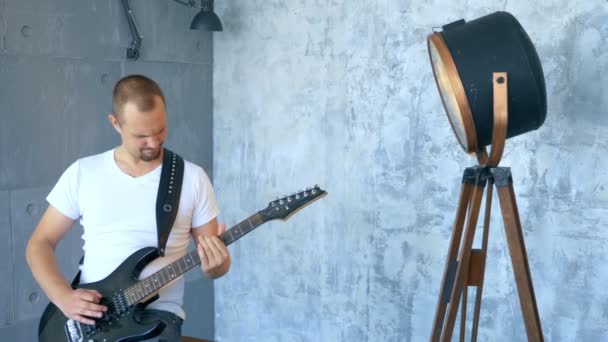 Bonito masculino músico tocando guitarra elétrica no estúdio — Vídeo de Stock