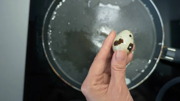Cerrar las manos femeninas preparar huevos fritos de huevos de codorniz — Foto de Stock