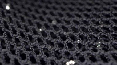Makro. Tekstil arka planı. Siyah guipure kumaşın lurex ile hareketi