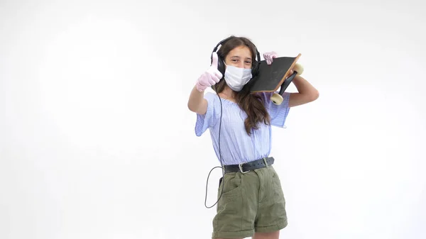 Изолированный белый фон. девушка в перчатках и медицинская маска со скейтбордом — стоковое фото