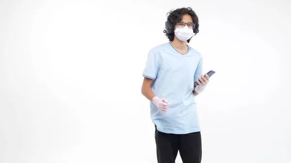 Isolated white background. teenage boy in a medical mask and gloves is dancing — Stock Photo, Image