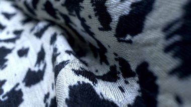 Makro. Tekstil arka planı. İpek kumaş kıvrımları. Renkli leopar boyanmış.