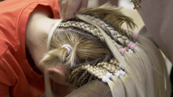 特写。理发师给一个金发姑娘做非洲辫子 — 图库照片
