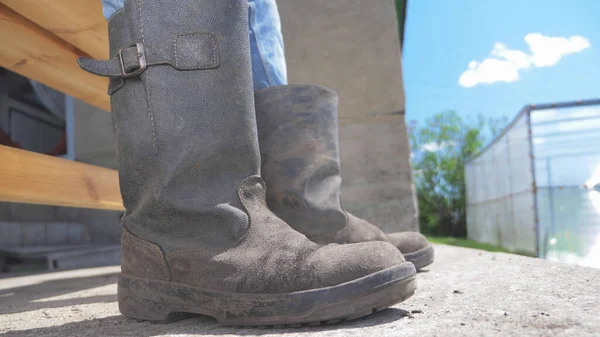 Primer plano. piernas en botas de lona en el campo contra un cielo azul —  Fotos de Stock