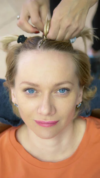 Een close-up. kapper doen afro pigtails naar een blond meisje — Stockfoto