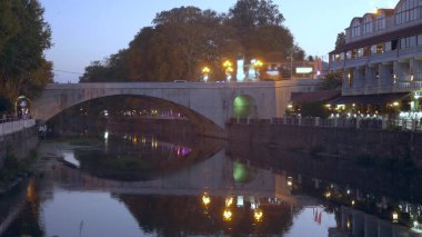 Arka plan bulanık. Nehrin üzerindeki yaya köprüsü. şehir ışıkları