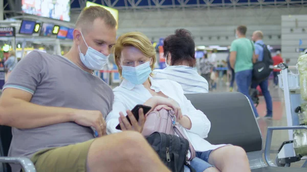 接近中だ。空港で医療マスクをした男女が — ストック写真