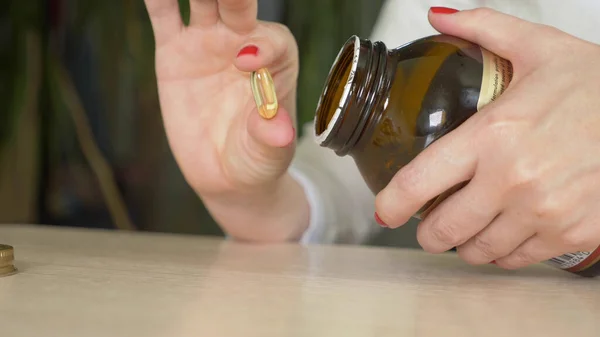 Крупним планом жіночі руки. жінка бере таблетки з пляшки — стокове фото