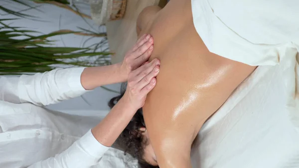 Masajista da masaje médico a joven rizado chico en spa — Foto de Stock