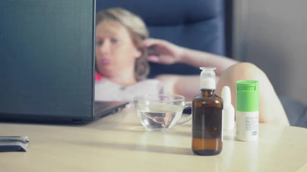 In scherpte medicijnen staan op de tafel waar wazig vrouw laptop gebruikt — Stockfoto