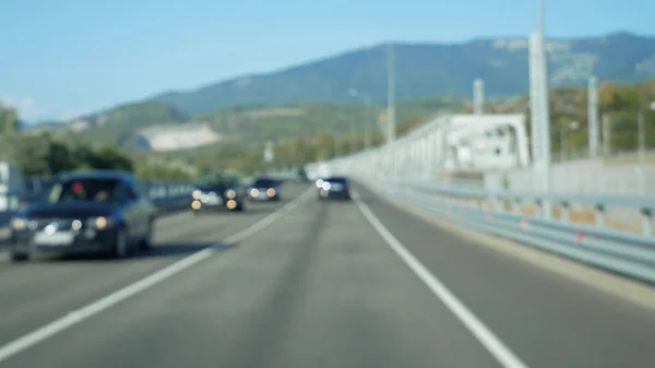 Vista desde un coche en movimiento. carretera entre las montañas en verano. pico de montaña — Foto de Stock