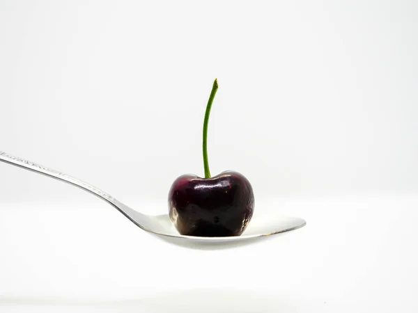 Beyaz arka plan ile kaşık üzerinde Kiraz meyve