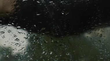 Adam cam sileceği kullanarak damla temizler