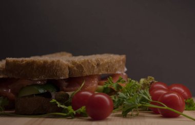 Ciabatta dilimleri kırmızı balık ve siyah arka plan üzerine ahşap plaka üzerinde beyaz krem peynir ile