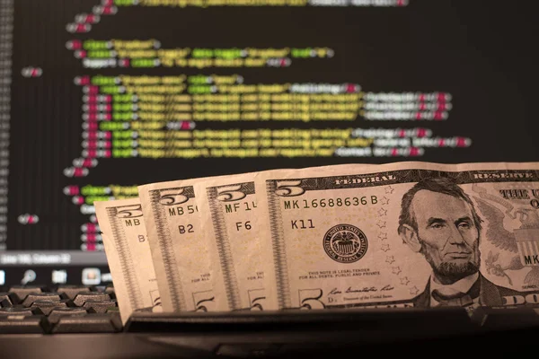 Para üstünde klavye ve bilgisayar ekran arka plan kodu içeren